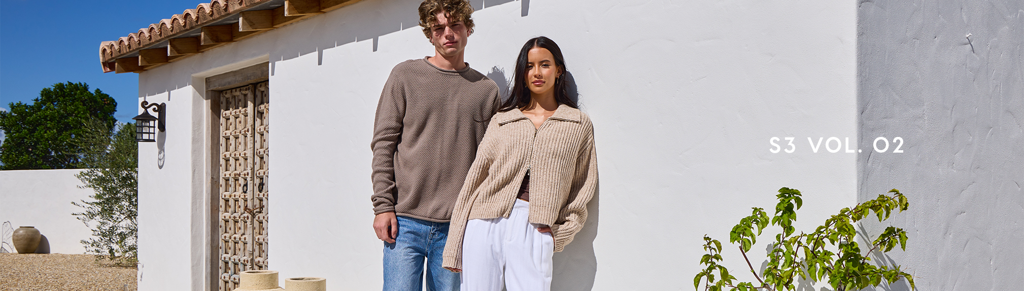 S3 Vol. 3 Lookbook. Image shows a woman and a man posing in a garden wearing City Beach fashion clothing